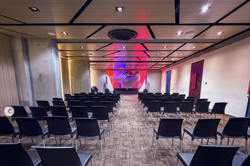 Pantalla LED gigante montada al fondo de un auditorio corporativo, con las sillas dispuestas frente a ella