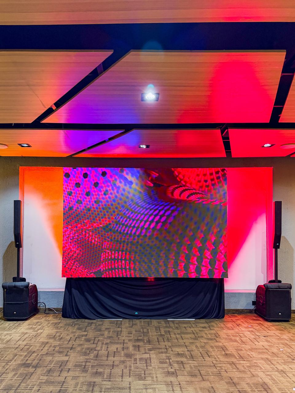 Pantalla LED con sonido line array e iluminación en el salón de un evento corporativo